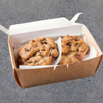 Two Blake's Brown Butter Double Chocolate Chip Cookies on a white plate with a chocolate chip drizzle.